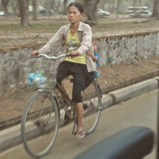Girl riding on the back of bicycle. 